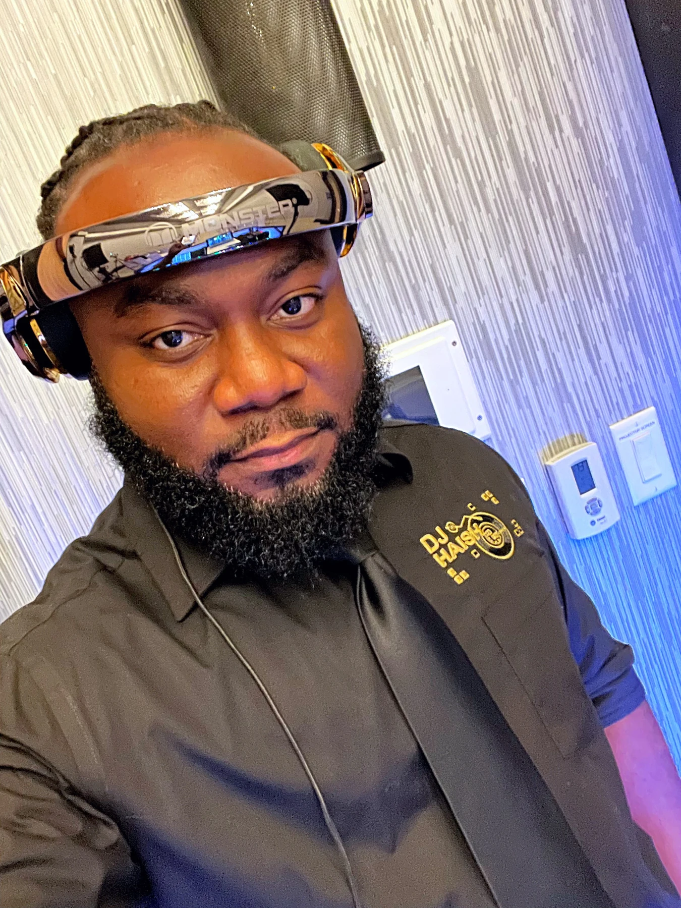 DJ Haish wearing signature headphones and branded black shirt